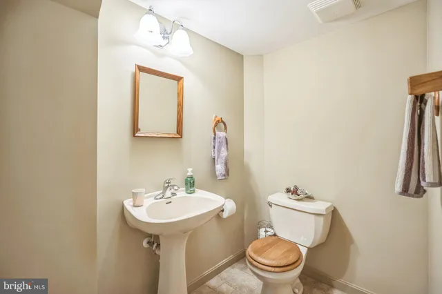 a bathroom with a toilet sink and mirror