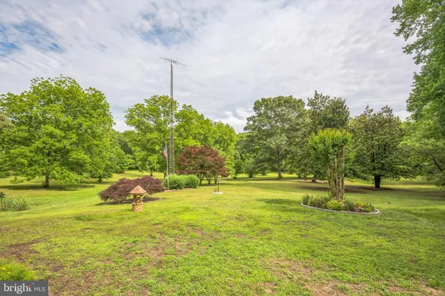 a backyard of a house with lots of green space and fountain