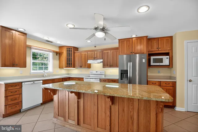 a kitchen with stainless steel appliances granite countertop a sink a stove and a refrigerator