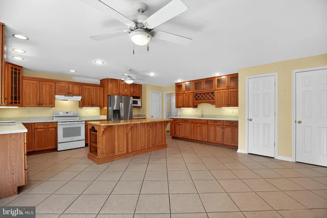 a large kitchen with a large counter top stainless steel appliances and cabinets