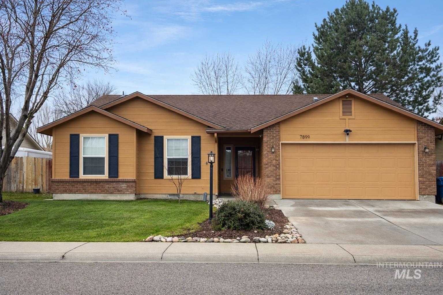 7899 West Prince Street Boise, ID 83714 - Photo 1 of 15 View of front of home featuring driveway, an attached garage, brick siding, and a shingled roof