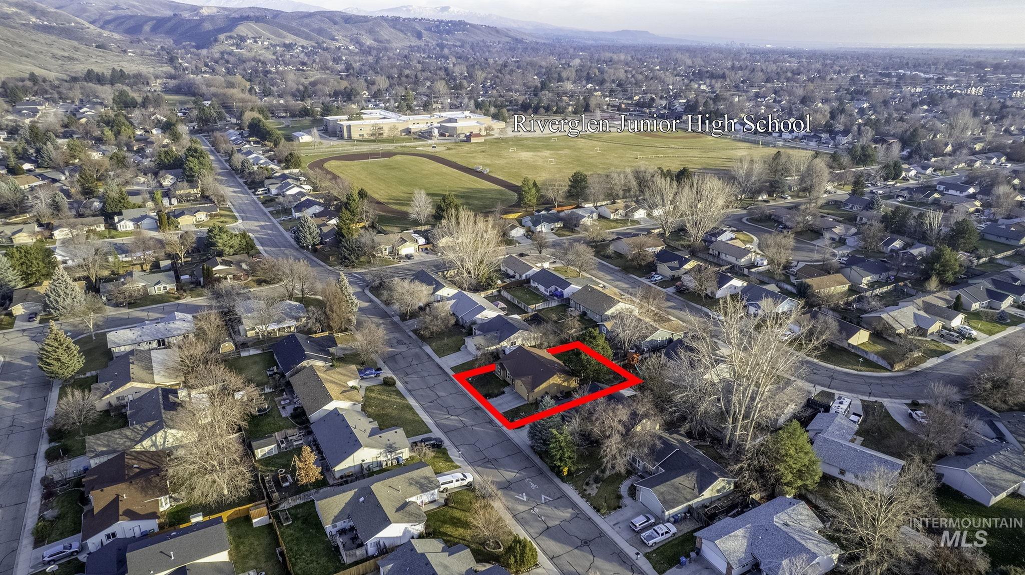 7899 West Prince Street Boise, ID 83714 - Photo 14 of 15 Aerial overview of property's location with property boundaries highlighted, nearby suburban area, and a mountain backdrop