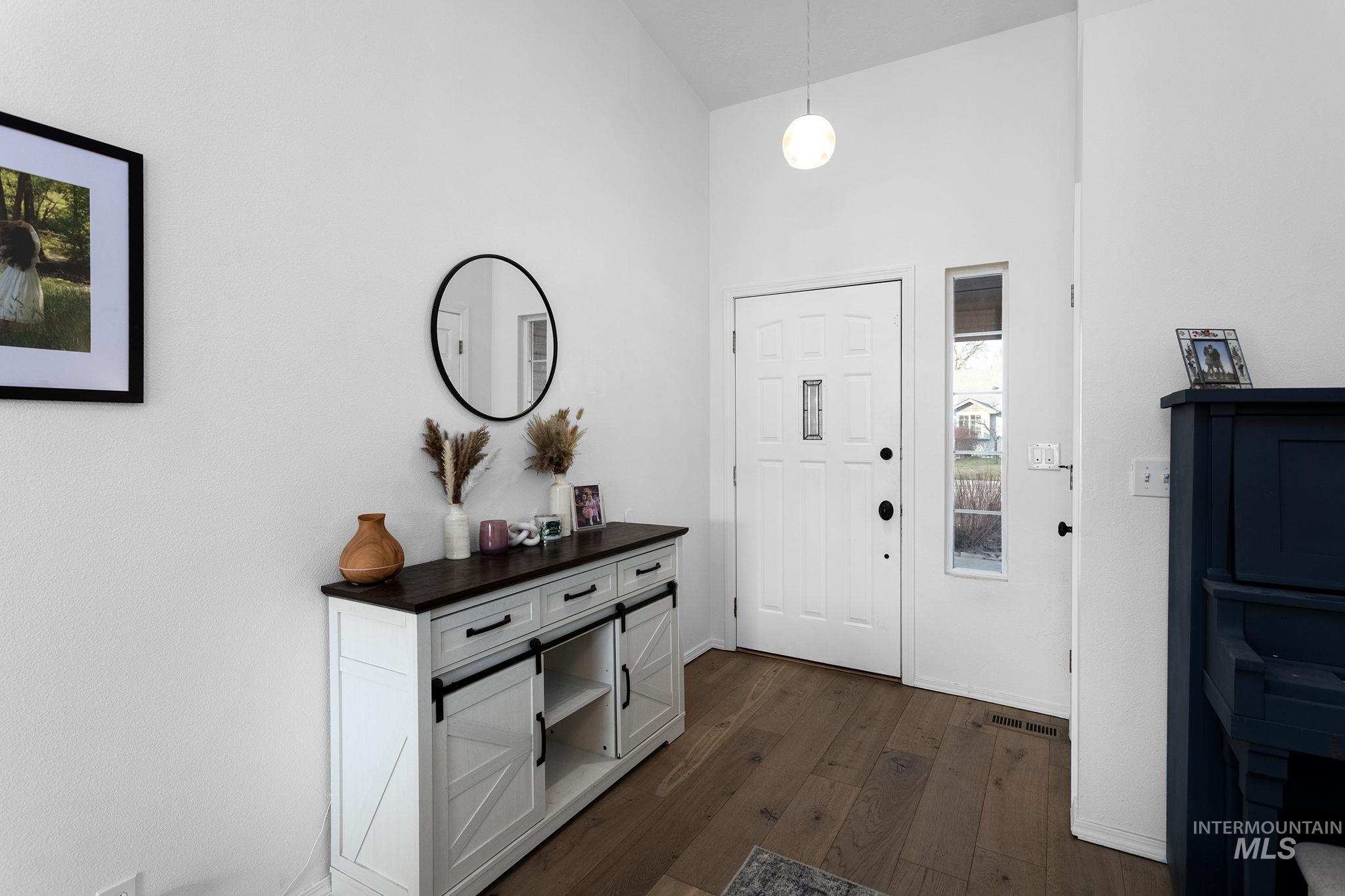 7899 West Prince Street Boise, ID 83714 - Photo 2 of 15 Foyer featuring dark wood finished floors and a towering ceiling