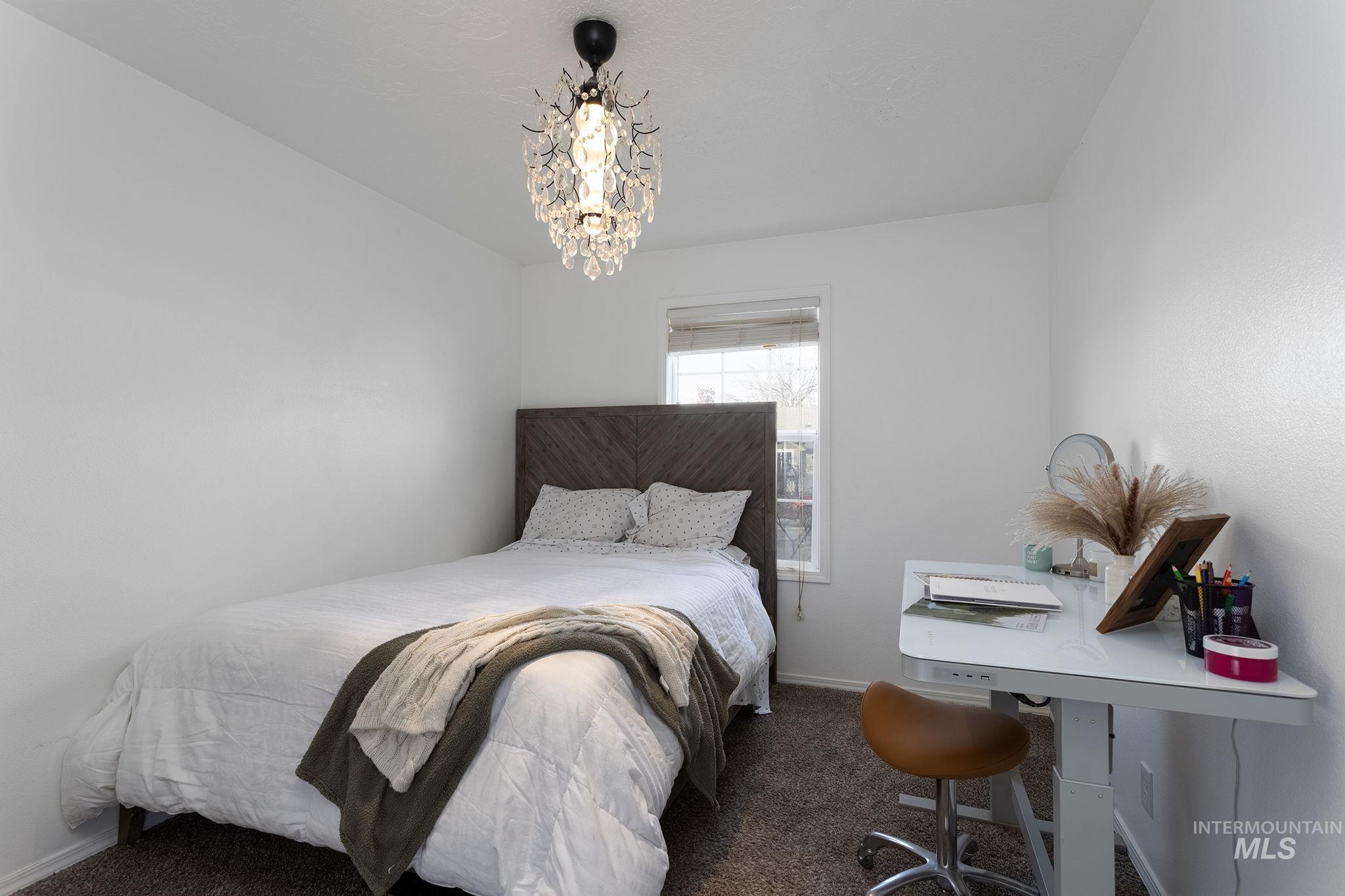 7899 West Prince Street Boise, ID 83714 - Photo 10 of 15 Bedroom featuring dark colored carpet, a chandelier, and a desk
