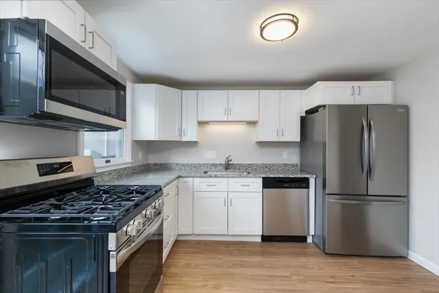 a kitchen with stainless steel appliances granite countertop a stove microwave sink and refrigerator