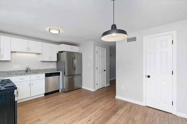 a kitchen with granite countertop a refrigerator and a stove