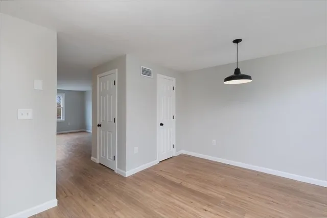 a view of empty room with wooden floor and ceiling fan