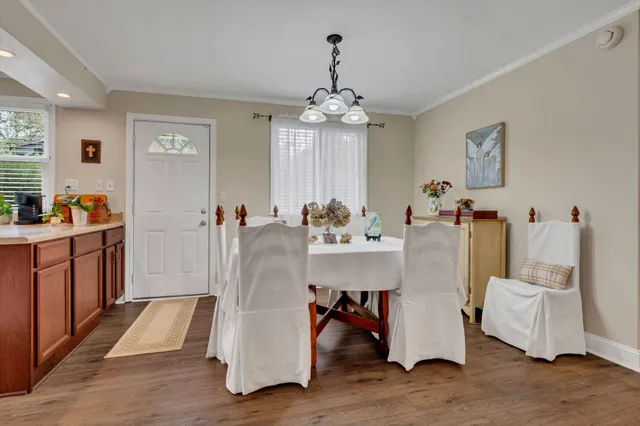a room with table chairs and wooden floor