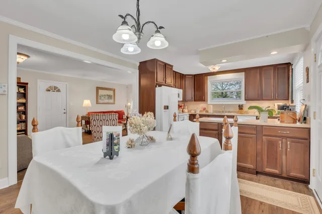 a view of kitchen with sink refrigerator dining table and chairs