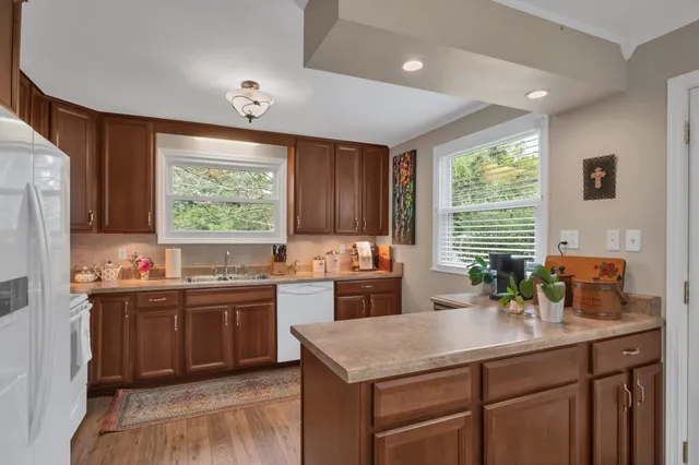 a kitchen with kitchen island granite countertop a sink stove and cabinets