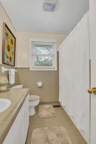 a bathroom with a granite countertop toilet and a sink