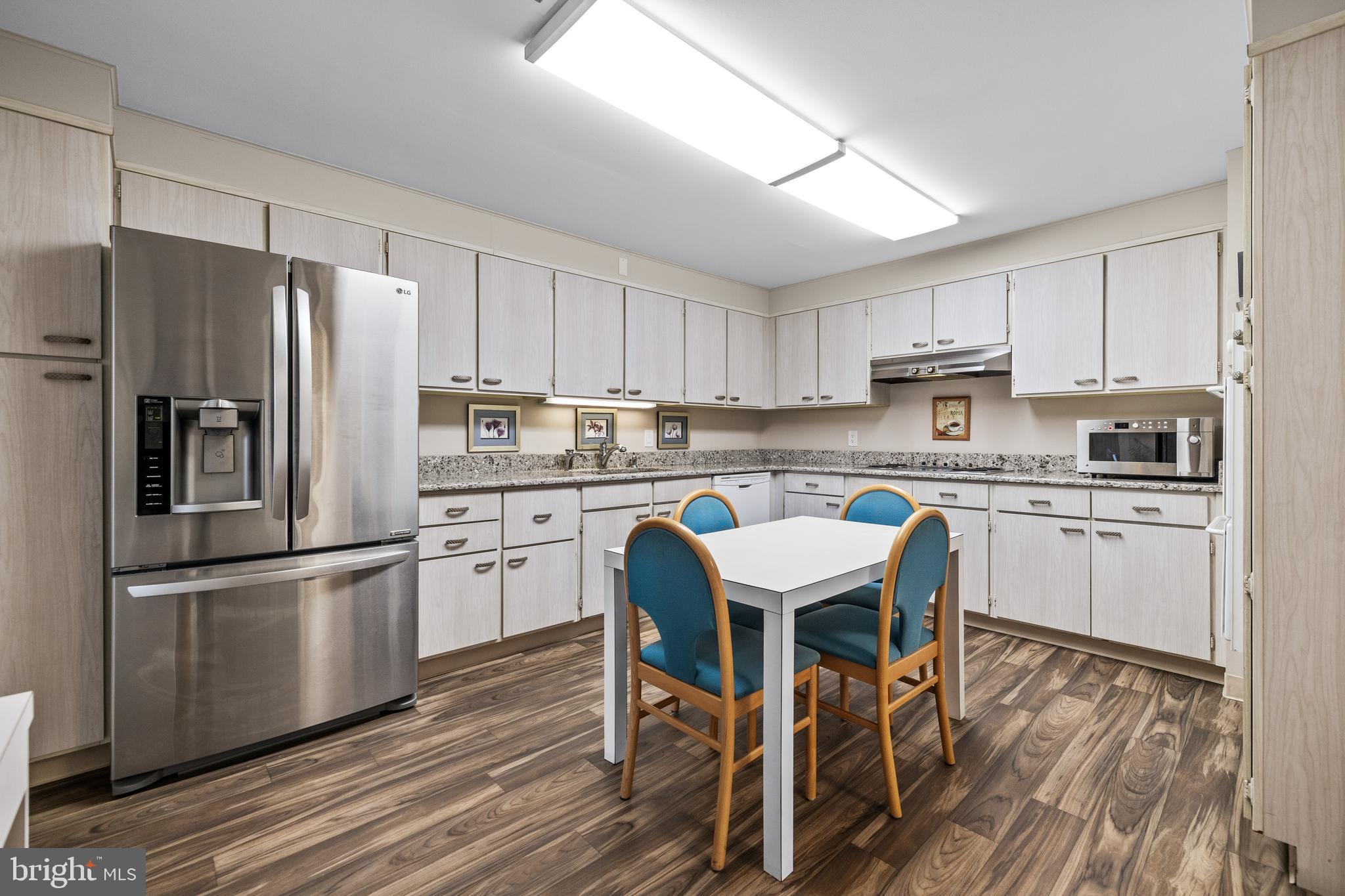 1 Slade Avenue, Unit 304 Baltimore, MD 21208 - Photo 12 of 44 a kitchen with a refrigerator a white stove top oven and white cabinets