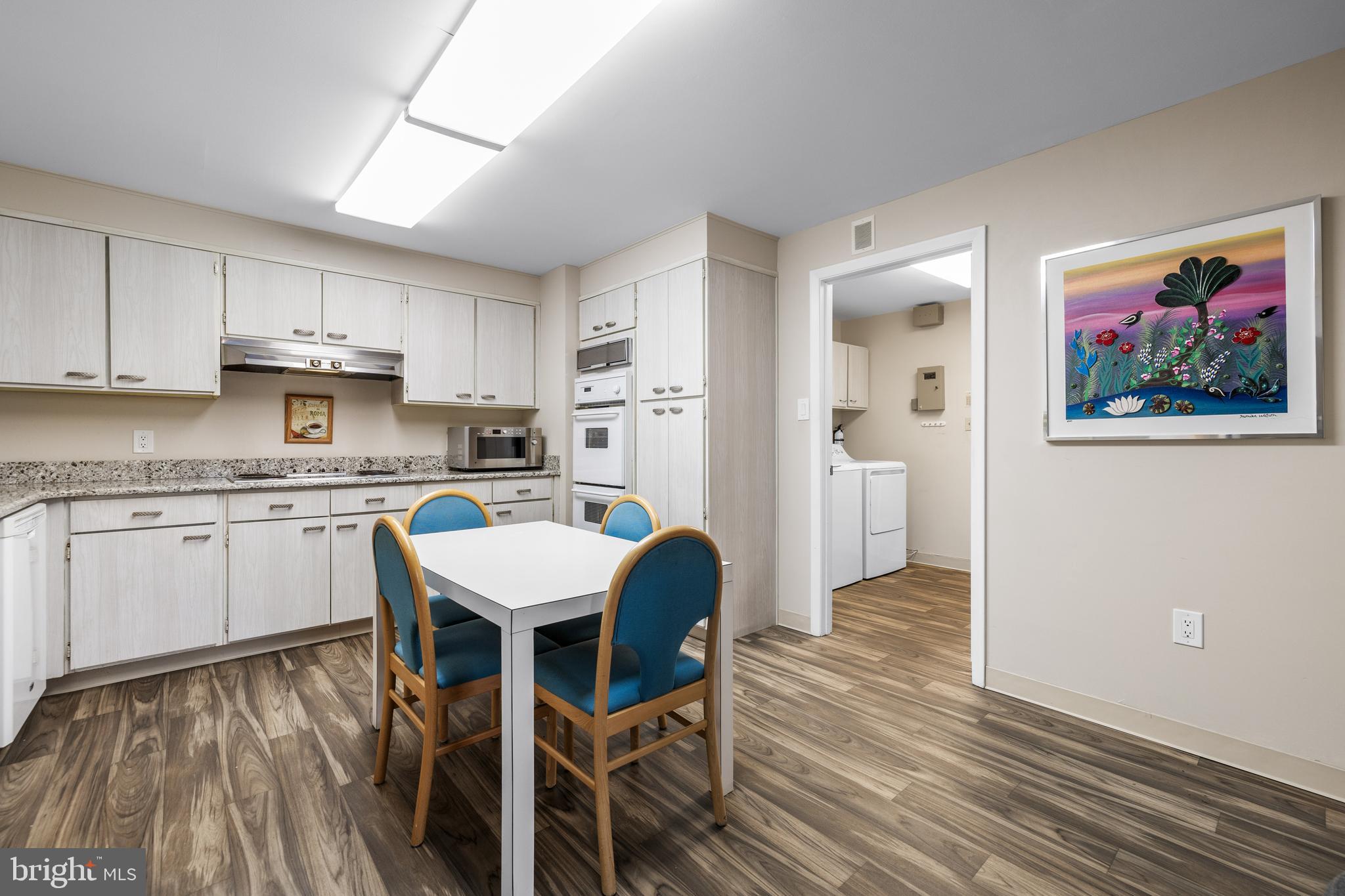 1 Slade Avenue, Unit 304 Baltimore, MD 21208 - Photo 13 of 44 a kitchen with a table chairs refrigerator and cabinets