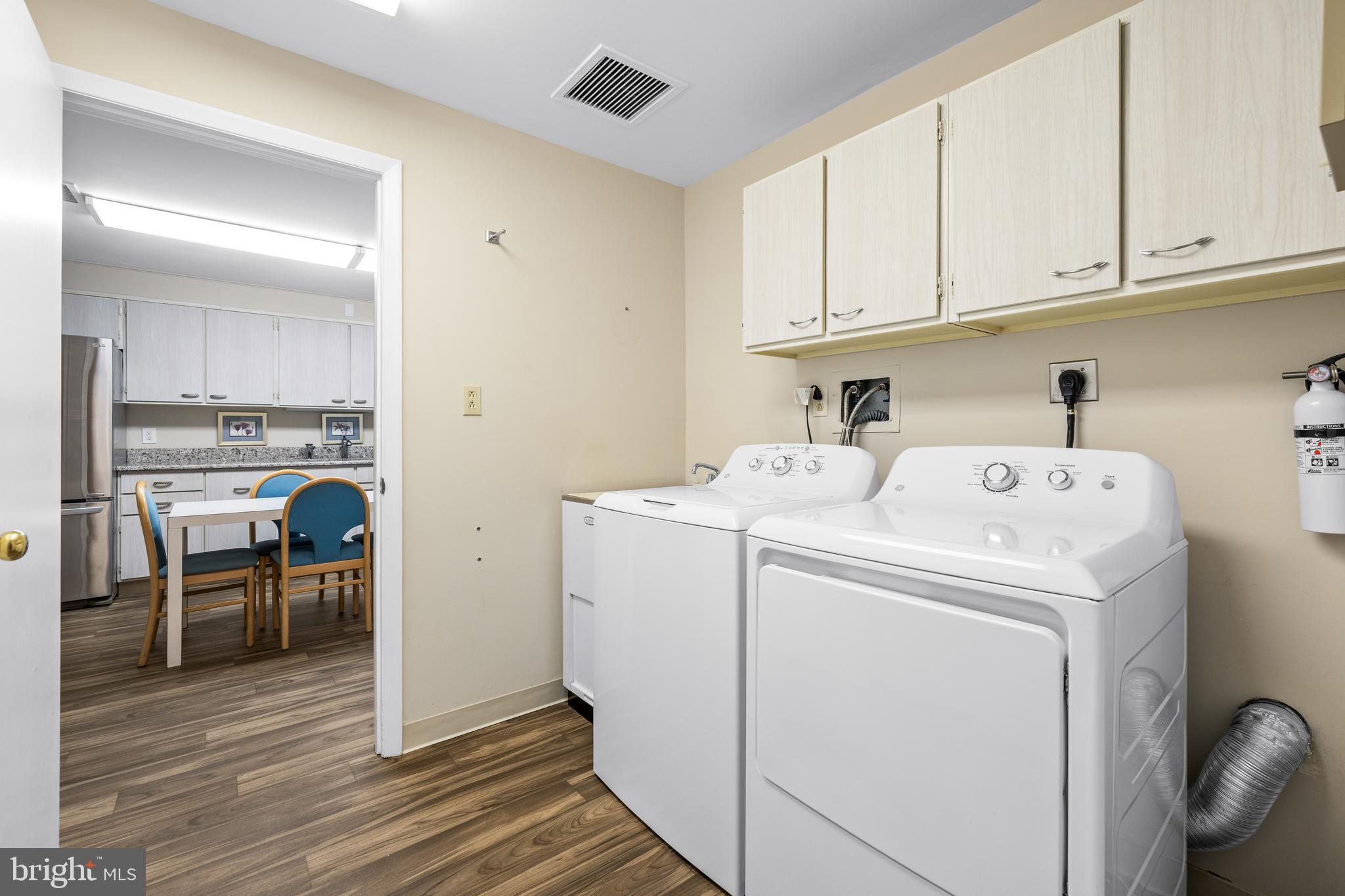 1 Slade Avenue, Unit 304 Baltimore, MD 21208 - Photo 16 of 44 a view of washer and dryer with kitchen in the background