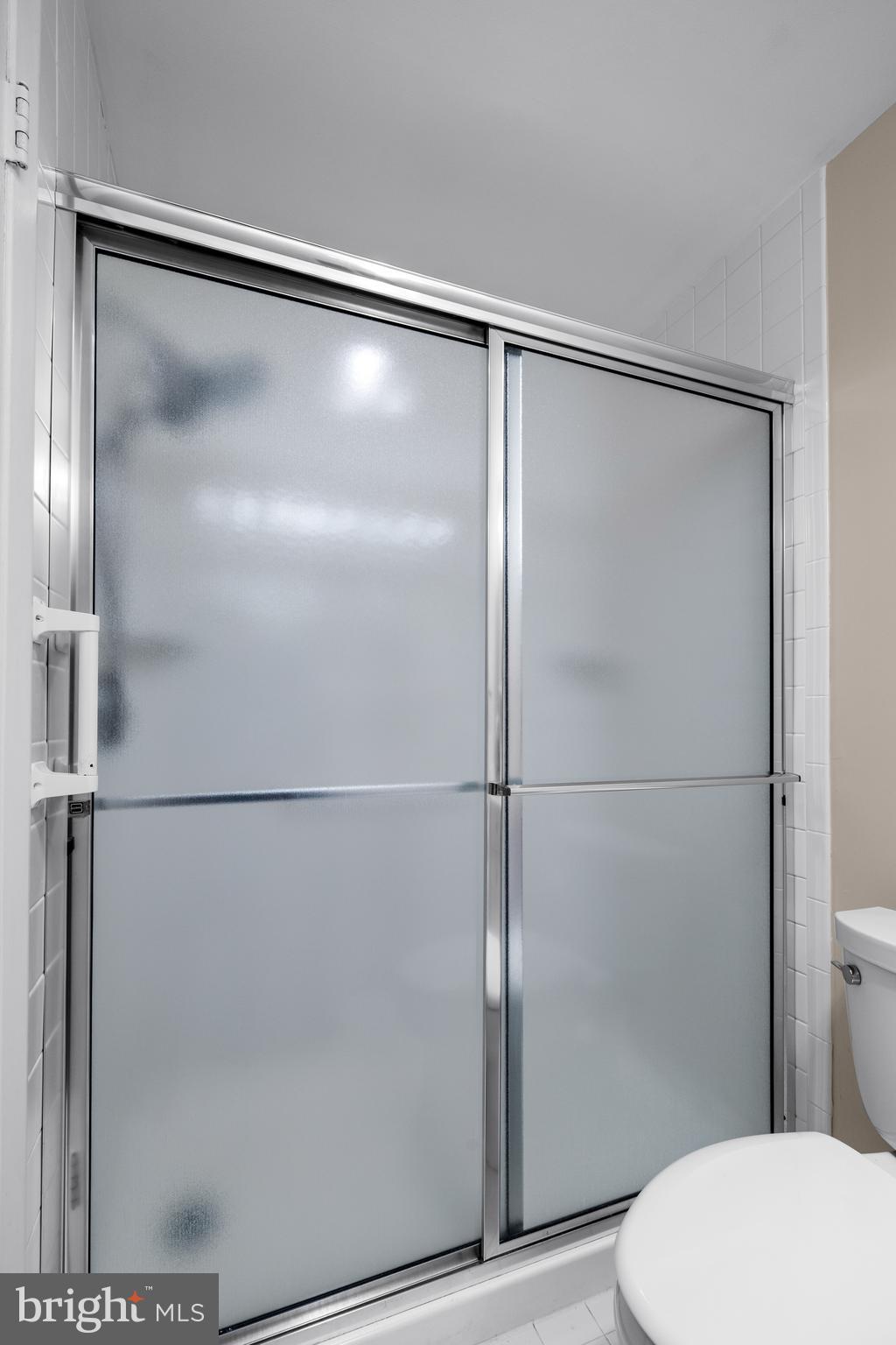 1 Slade Avenue, Unit 304 Baltimore, MD 21208 - Photo 37 of 44 a bathroom with a glass shower door