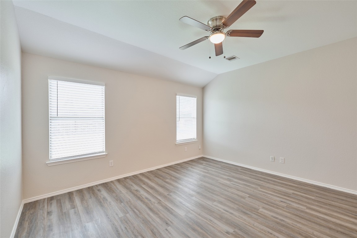 24439 Raindrop Poppy Drive Spring, TX 77373 - Photo 17 of 27 an empty room with wooden floor ceiling fan and windows