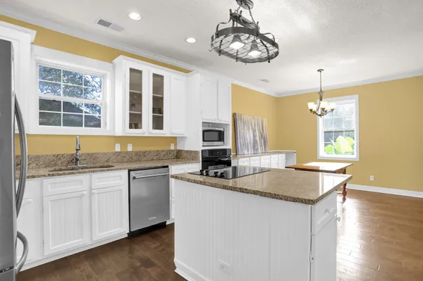 a kitchen with stainless steel appliances granite countertop a sink and dishwasher a stove top oven with wooden floor
