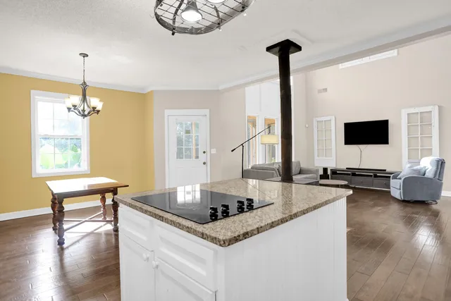 a kitchen with stainless steel appliances granite countertop a sink and dishwasher a stove top oven with wooden floor