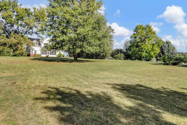 a view of a house with a yard and sitting area