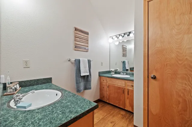 a bathroom with a granite countertop sink a mirror and a shower