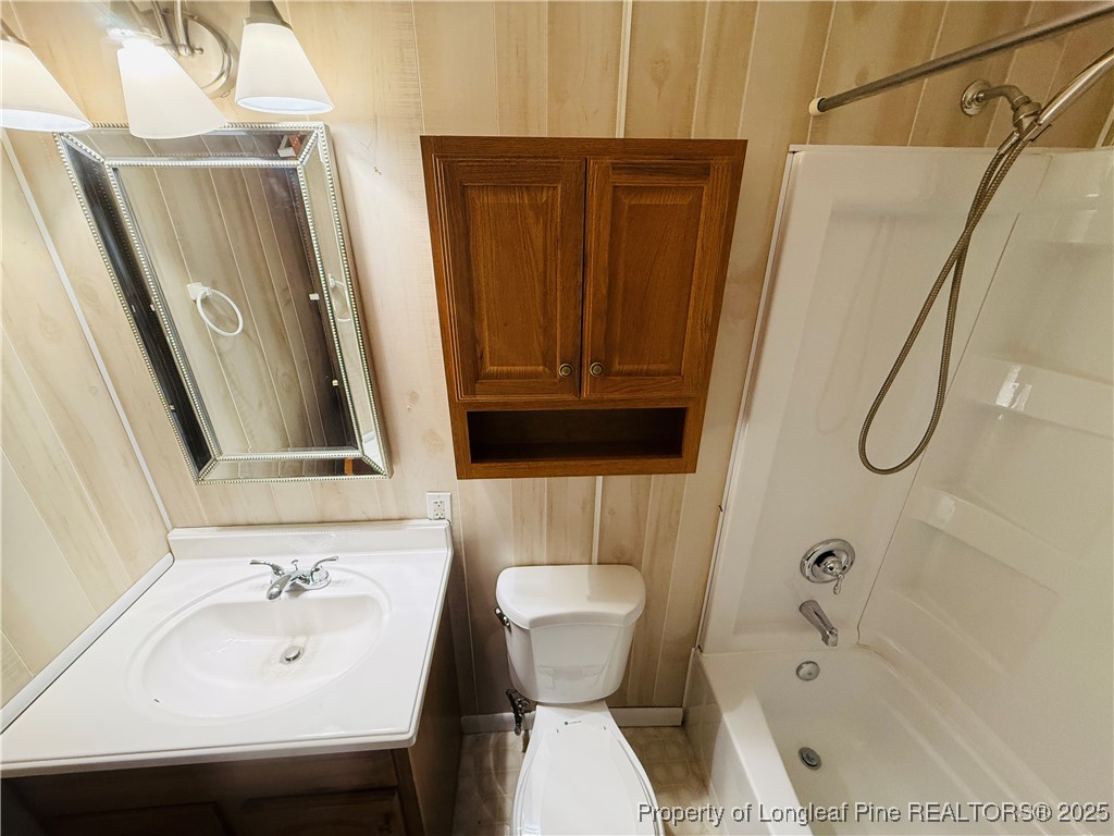 611 Reggie Court Spring Lake, NC 28390 - Photo 18 of 20 a bathroom with a sink a toilet and shower curtain