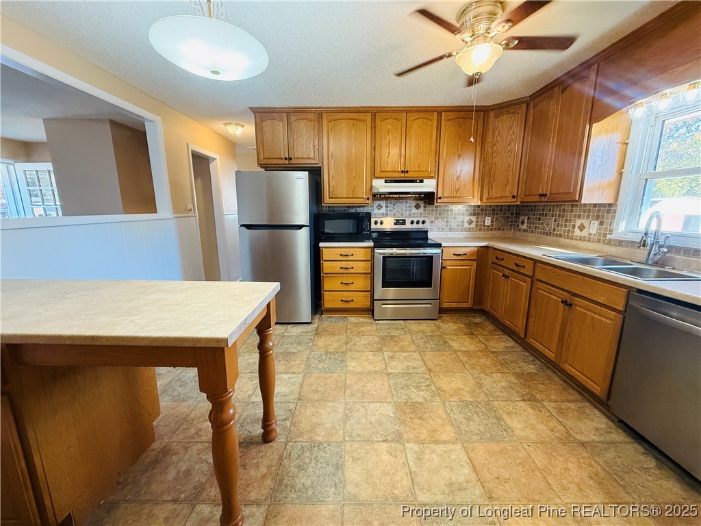 611 Reggie Court Spring Lake, NC 28390 - Photo 9 of 20 a kitchen with stainless steel appliances granite countertop a sink dishwasher stove top oven a refrigerator with island and chairs