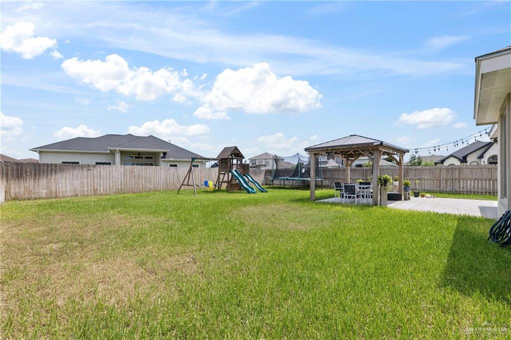 1904 Ridgeway Circle Edinburg, TX 78542 - Photo 28 of 32 Expansive backyard featuring a concrete patio, a wooden gazebo, and a wooden privacy fence