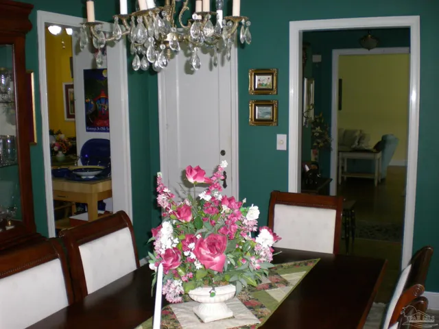 a flowers room with a table chair and a chandelier