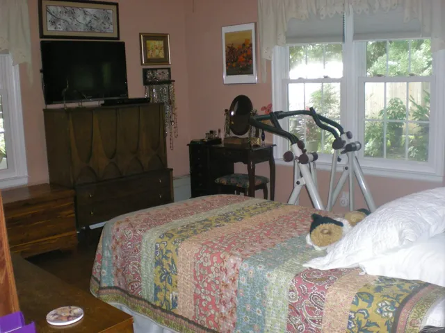 a bedroom with a bed and a flat tv screen next to a window