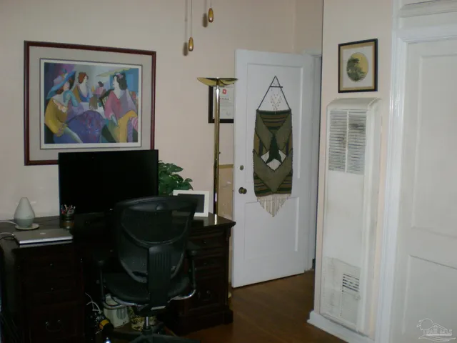 a view of a workspace with furniture and wooden floor