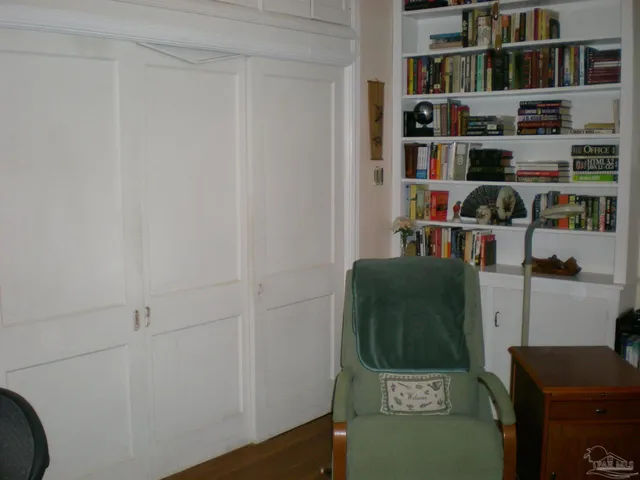 a view of a workspace with furniture and a book shelf