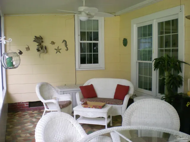 a view of a chairs and table in the back yard of the house and a chair