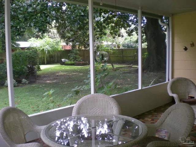 a view of a house with potted plants and a table and chair