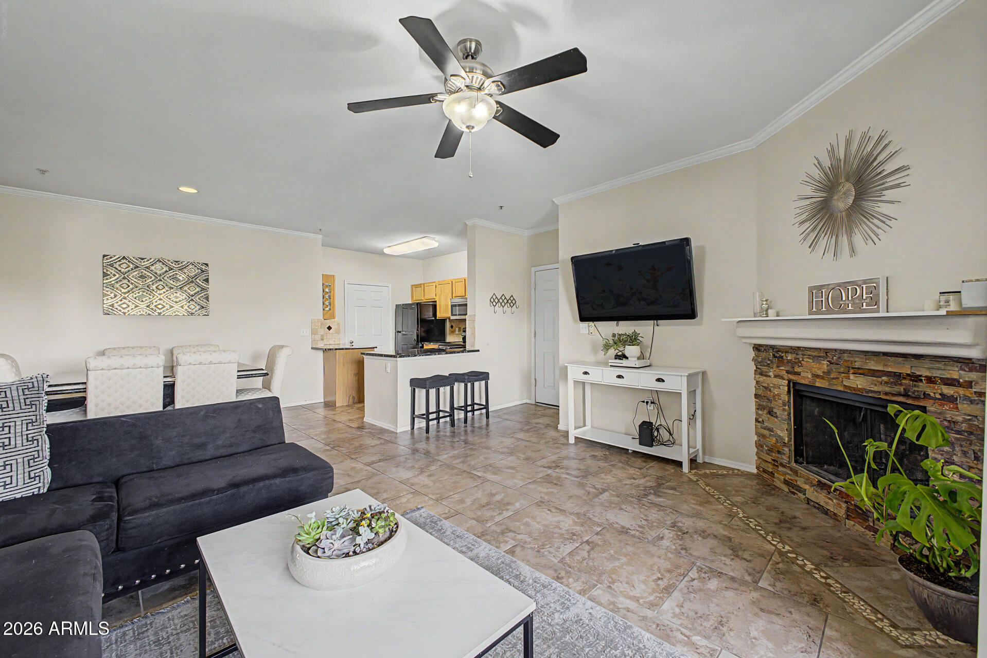 5401 East Van Buren Street, Unit 3017 Phoenix, AZ 85008 - Photo 2 of 37 a living room with furniture a fireplace and a flat screen tv
