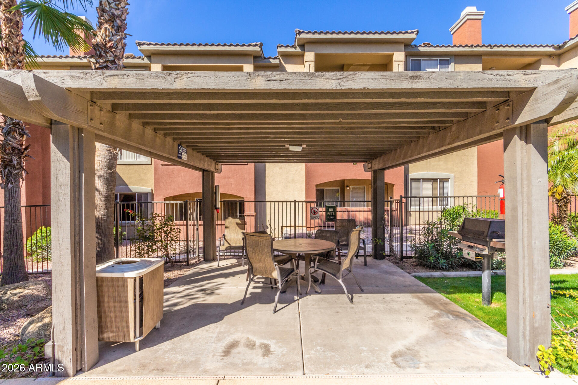 5401 East Van Buren Street, Unit 3017 Phoenix, AZ 85008 - Photo 29 of 37 a view of a patio with table and chairs potted plants with wooden floor and fence