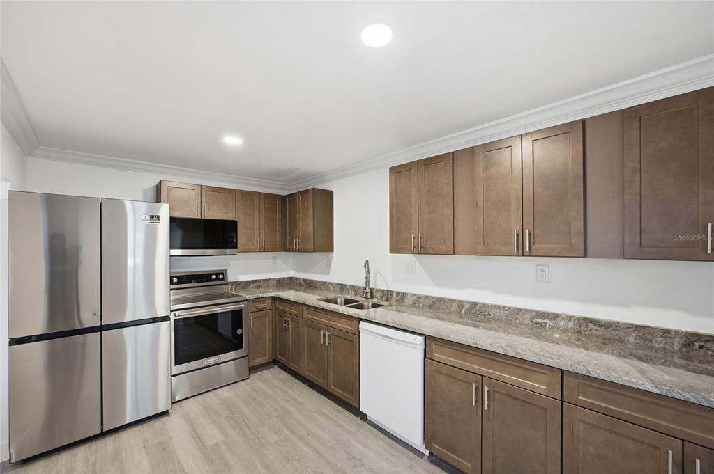 1908 Macomber Avenue Clearwater, FL 33755 - Photo 11 of 24 a kitchen with stainless steel appliances granite countertop a sink stove and refrigerator