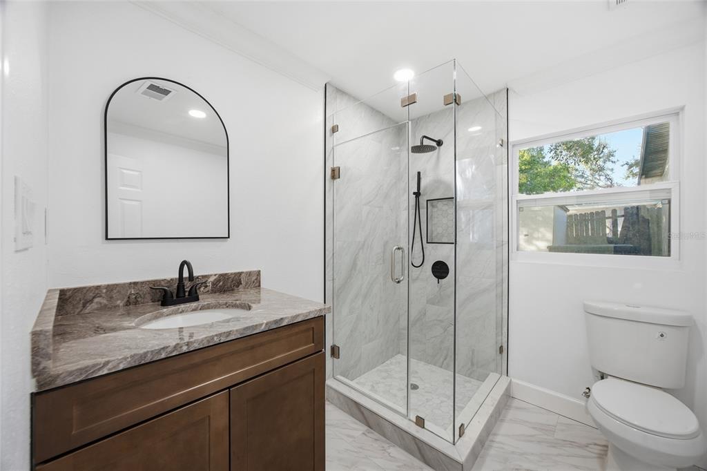 1908 Macomber Avenue Clearwater, FL 33755 - Photo 15 of 24 a bathroom with a granite countertop sink toilet and shower