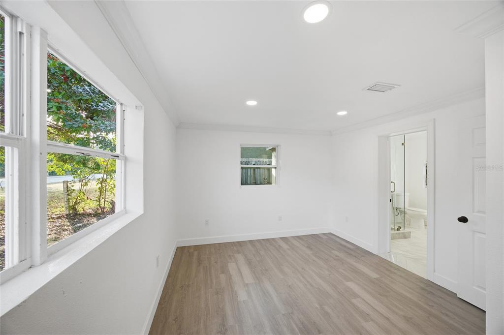 1908 Macomber Avenue Clearwater, FL 33755 - Photo 18 of 24 an empty room with wooden floor and windows