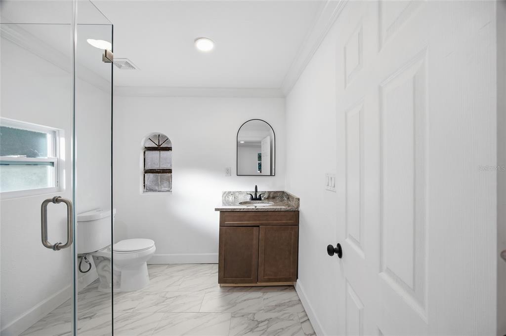 1908 Macomber Avenue Clearwater, FL 33755 - Photo 19 of 24 a bathroom with a granite countertop sink toilet and shower