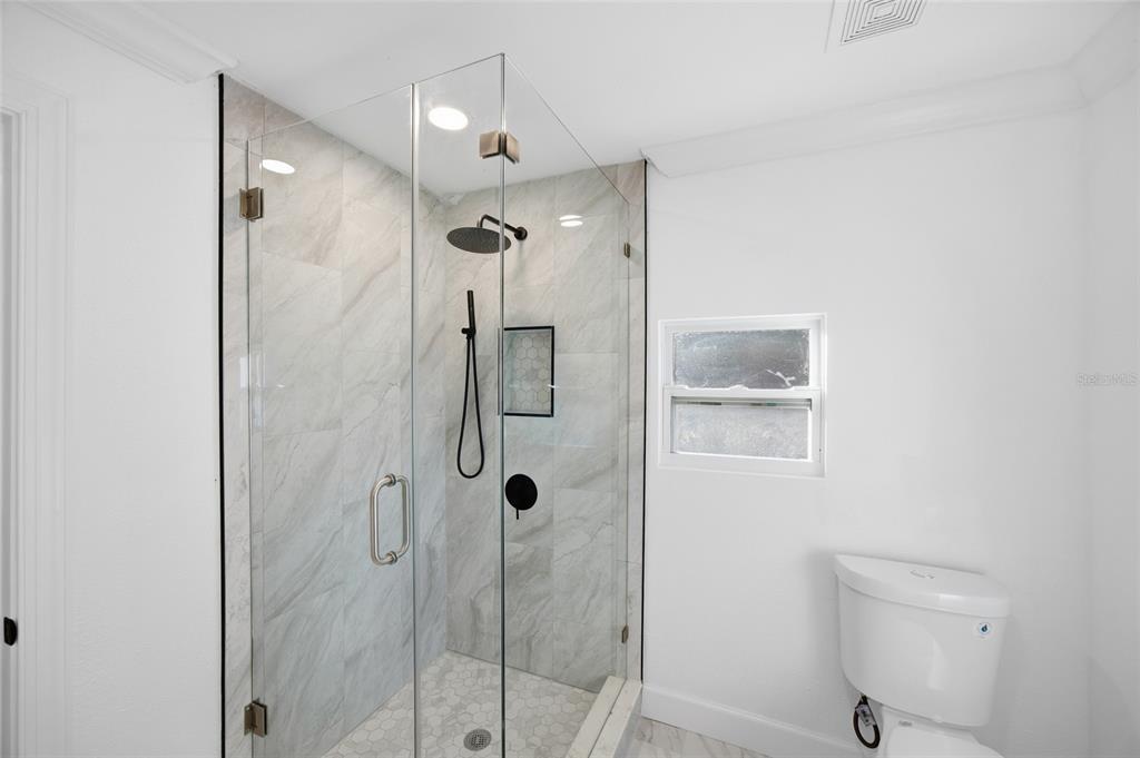 1908 Macomber Avenue Clearwater, FL 33755 - Photo 20 of 24 a bathroom with a shower and a toilet