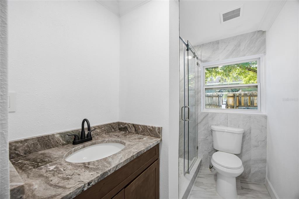 1908 Macomber Avenue Clearwater, FL 33755 - Photo 23 of 24 a bathroom with a granite countertop toilet and a sink