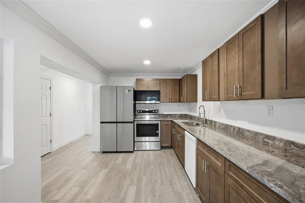 1908 Macomber Avenue Clearwater, FL 33755 - Photo 10 of 24 a large kitchen with a stove top oven a sink and dishwasher a refrigerator with wooden floor