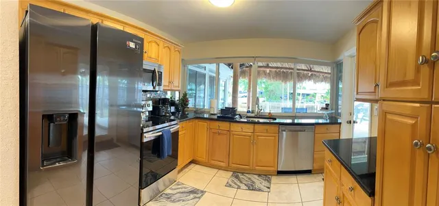 a kitchen with stainless steel appliances granite countertop a refrigerator a sink a stove and island