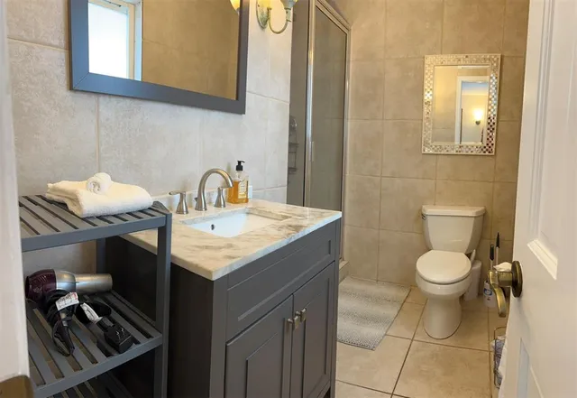 a bathroom with a granite countertop toilet sink and mirror