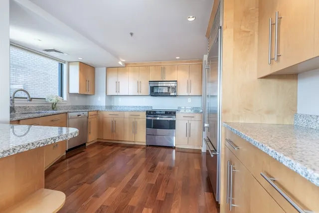 a kitchen with stainless steel appliances granite countertop a sink stove and refrigerator
