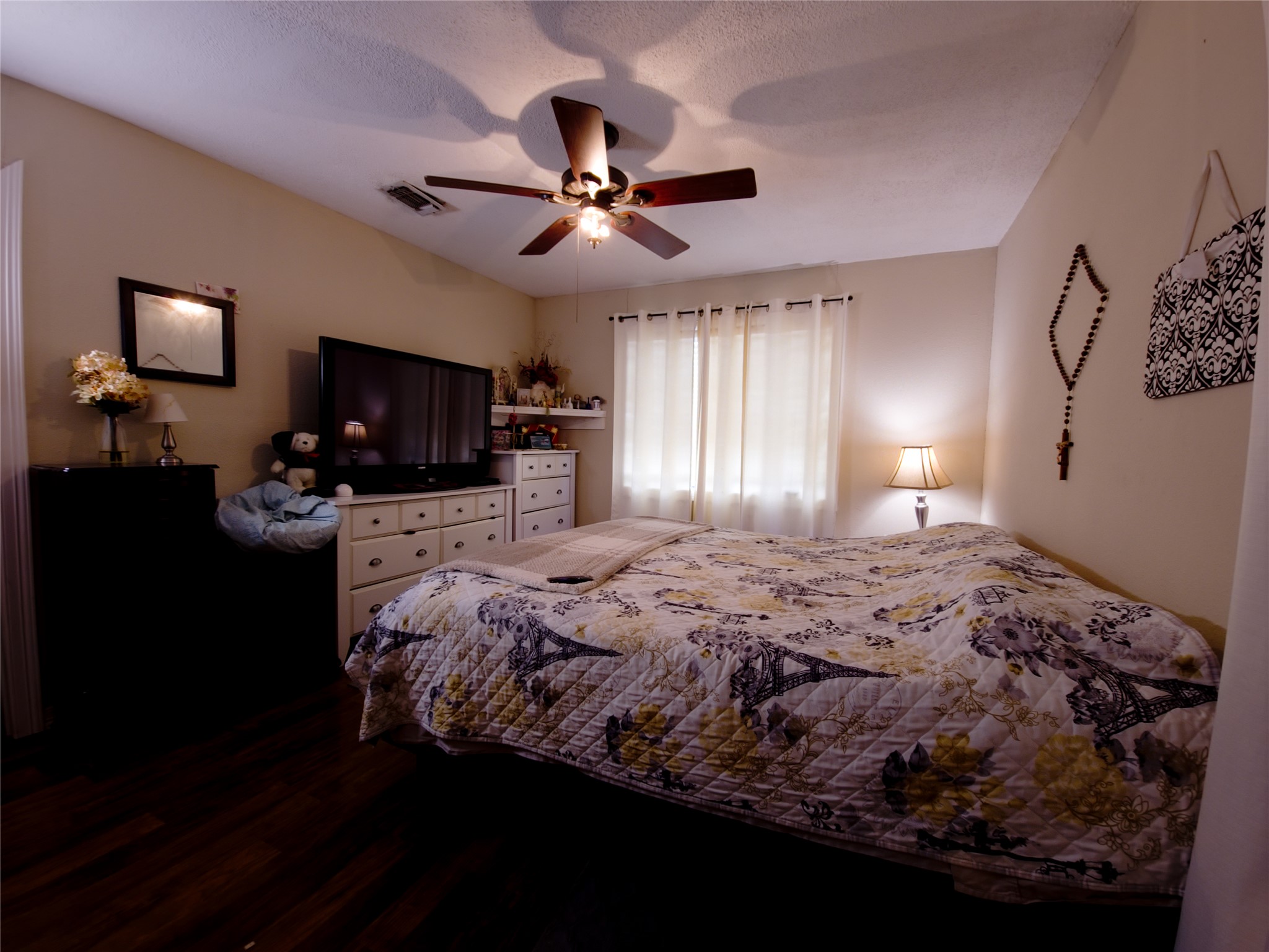 911 Brazos Street Lockhart, TX 78644 - Photo 12 of 22 Bedroom with dark wood-type flooring, a ceiling fan, and a textured ceiling