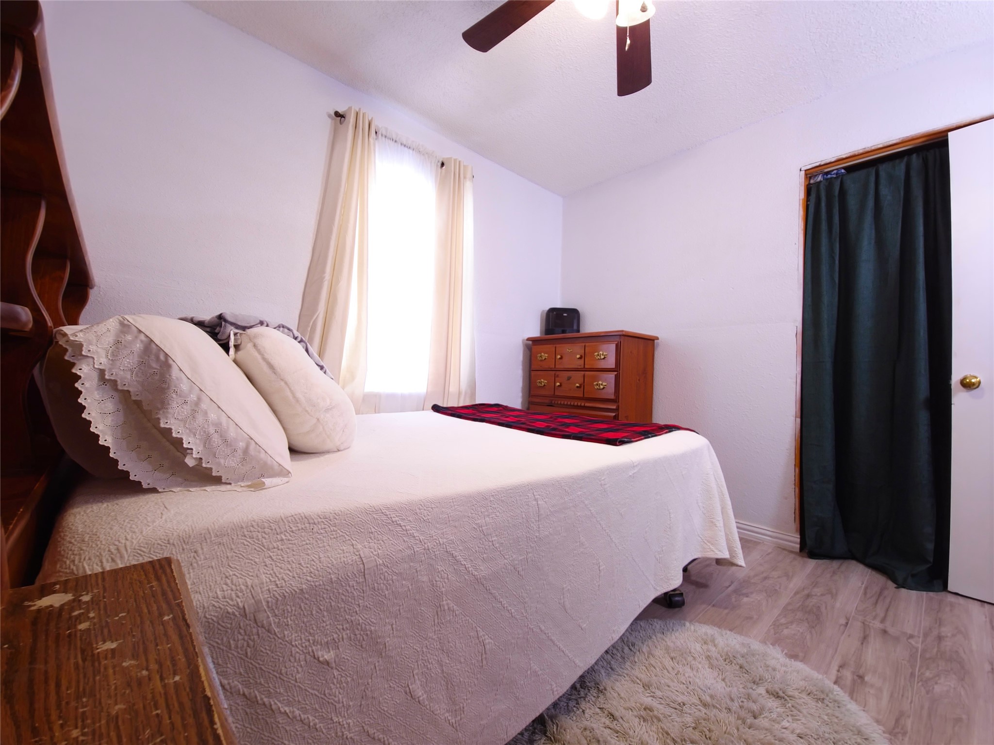 911 Brazos Street Lockhart, TX 78644 - Photo 16 of 22 Bedroom featuring wood finished floors, ceiling fan, and vaulted ceiling