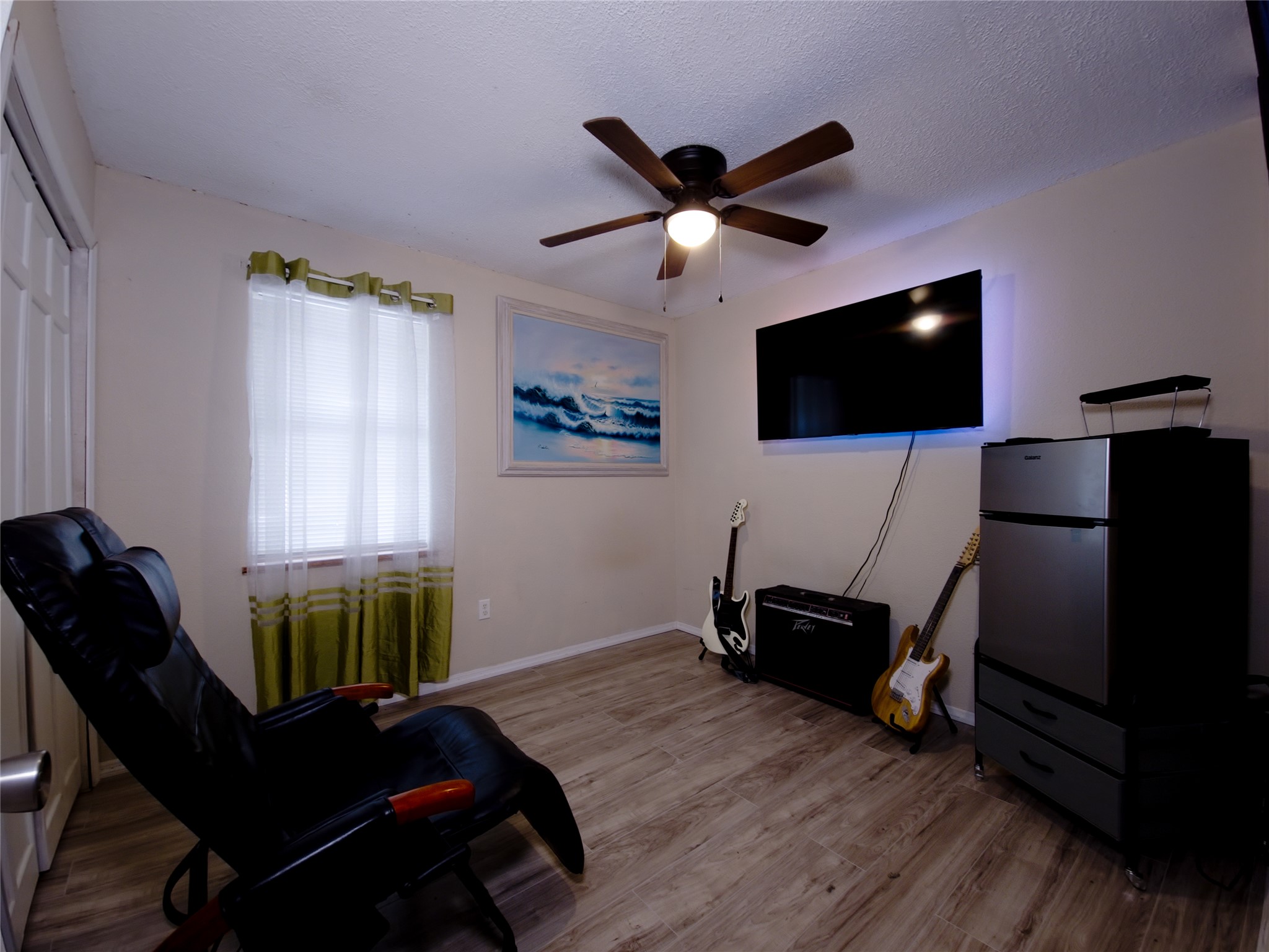 911 Brazos Street Lockhart, TX 78644 - Photo 17 of 22 Living area featuring light wood-style floors, ceiling fan, and a textured ceiling