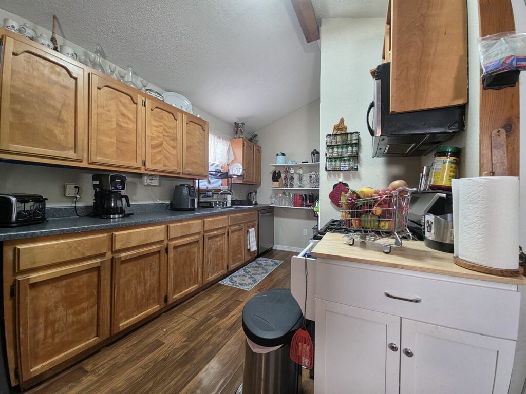 911 Brazos Street Lockhart, TX 78644 - Photo 20 of 22 The kitchen features extensive wooden cabinetry and dark countertops, providing ample storage and workspace