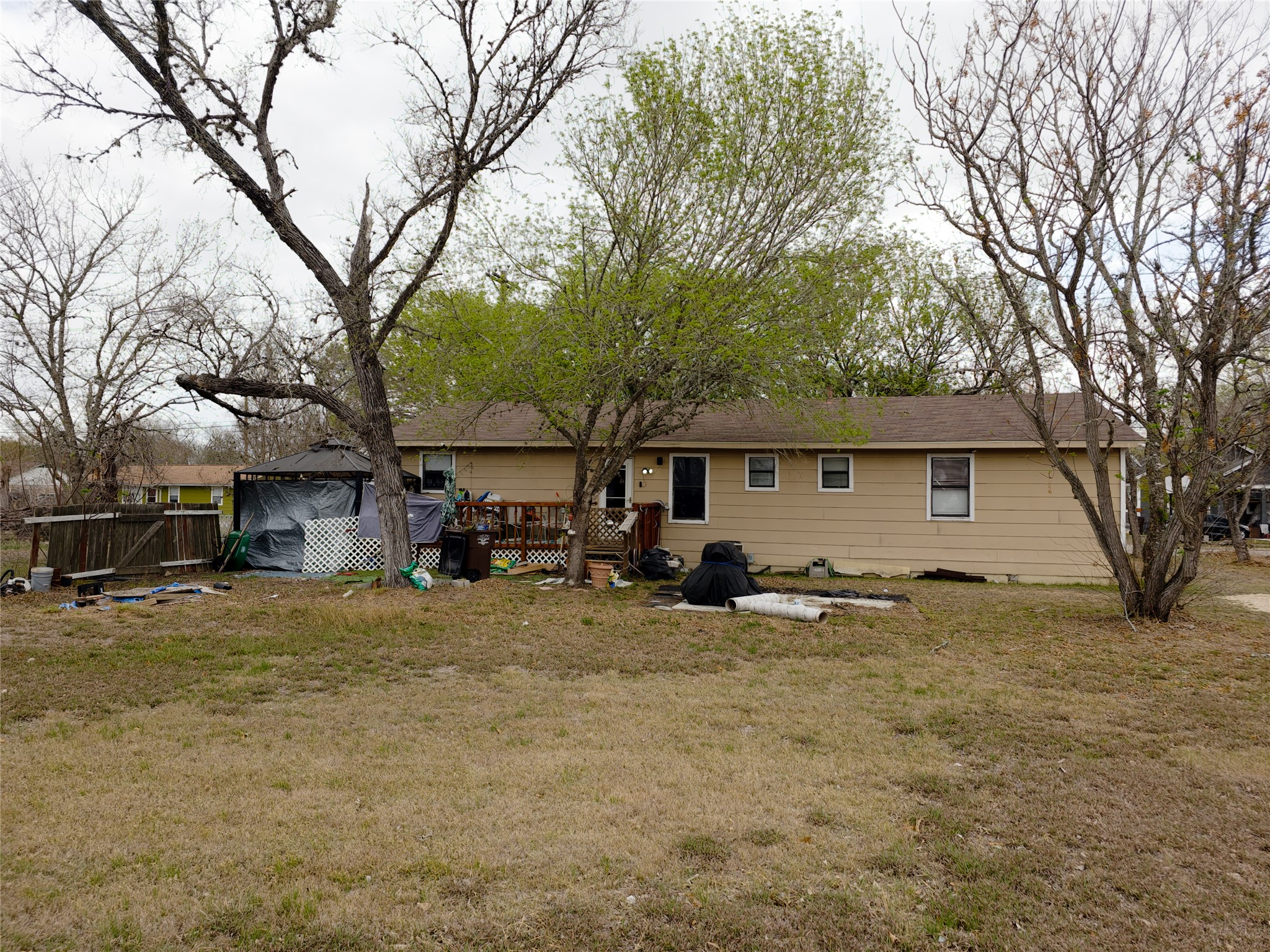 911 Brazos Street Lockhart, TX 78644 - Photo 4 of 22 Back of property featuring a deck and a lawn